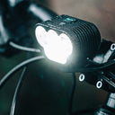 Magicshine Monteer 5000 MTB headlight mounted on bike handlebar with bright light and water droplets